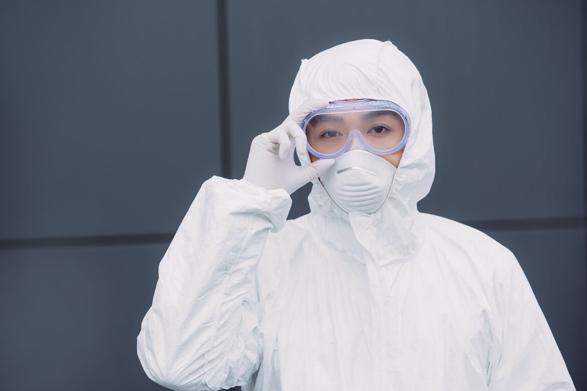 asian epidemiologist in hazmat suit and respirator