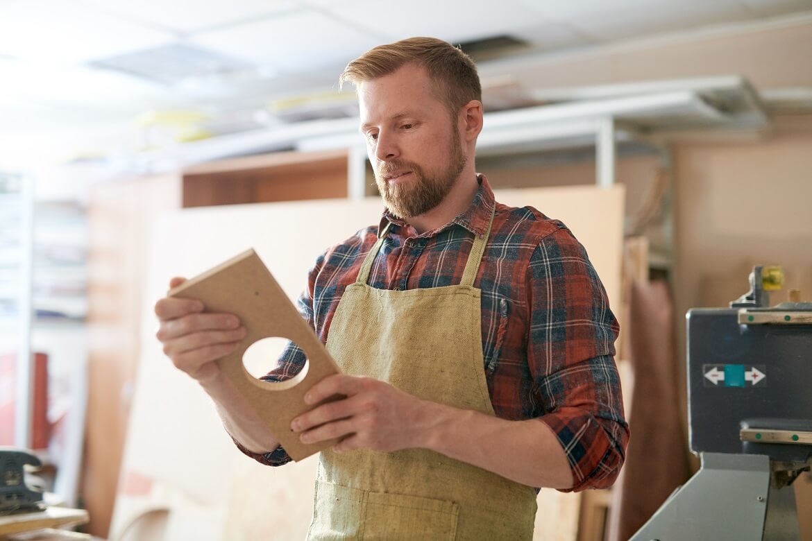 woodworker holding a piece of wood