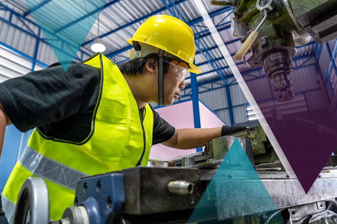 Young apprentice working in a manufacturing plant, wearing personal protective equipment