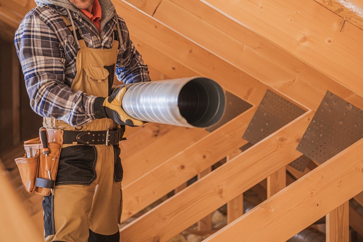 HVAC worker with piece of air duct pipeline in his hands