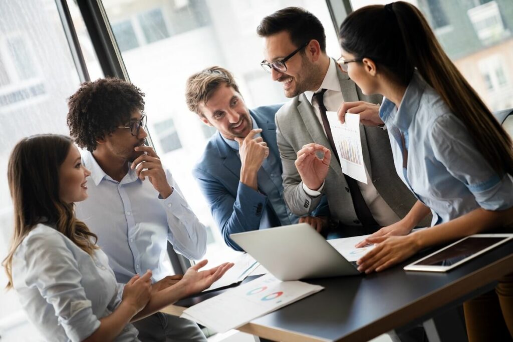 Colleagues chatting and smiling during a work meeting