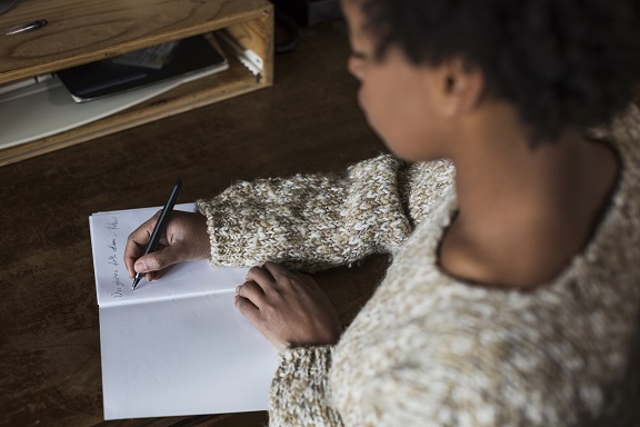 Young black woman writing in notebook