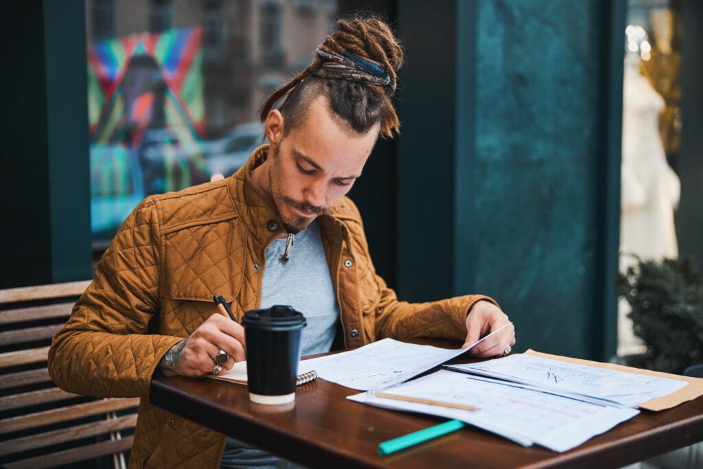 Young man studying in street cafe