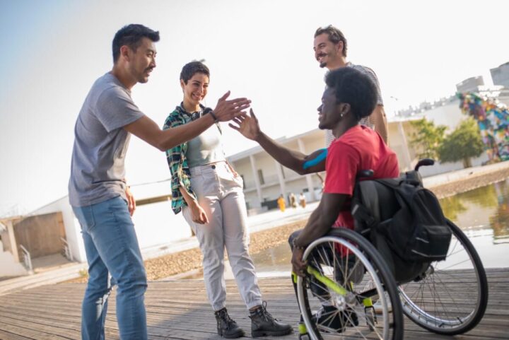 a man greeting another his friend in a wheelchair